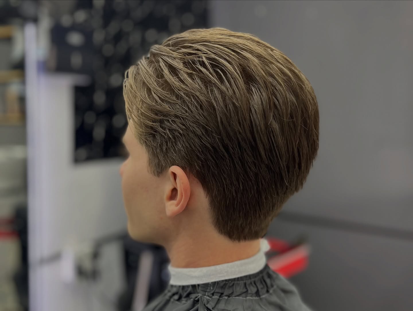 Corte clásico con volumen y peinado hacia atrás
